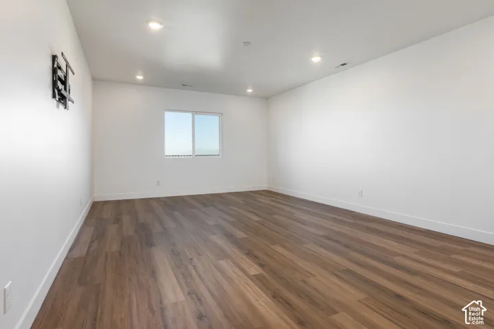 Wood-finish flooring, recessed lighting, and a white color palette
