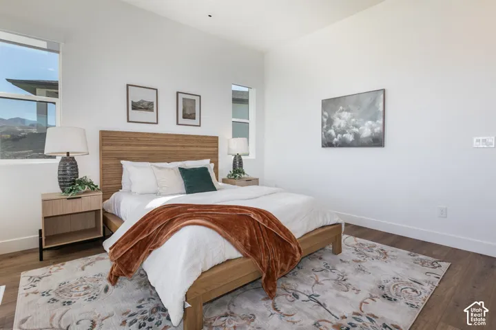 Wood-finish flooring, white walls, and multiple windows