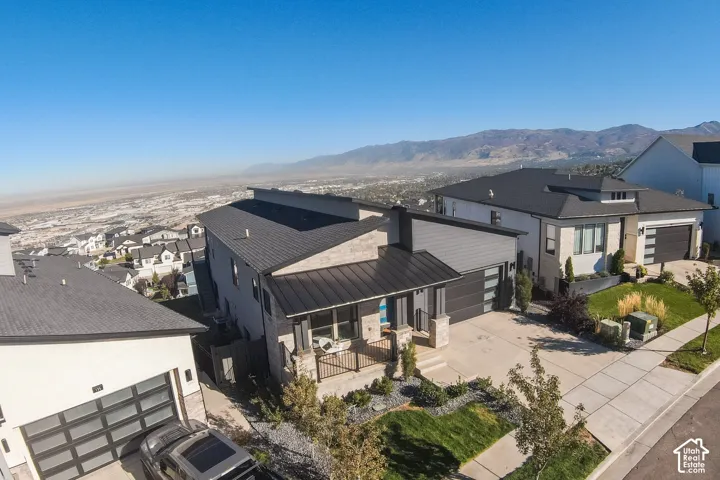 Aerial View - Modern architectural design featuring varied roofing, stone and siding accents, contemporary garage doors, and a concrete driveway