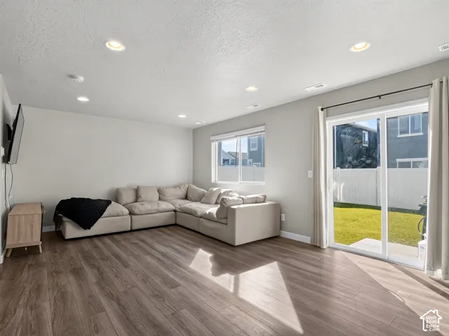 Wood-finish flooring, recessed lighting, and a sliding glass door providing exterior access