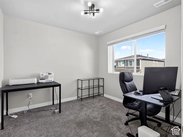 Carpeted room with a large window, a modern ceiling light fixture, and light gray walls