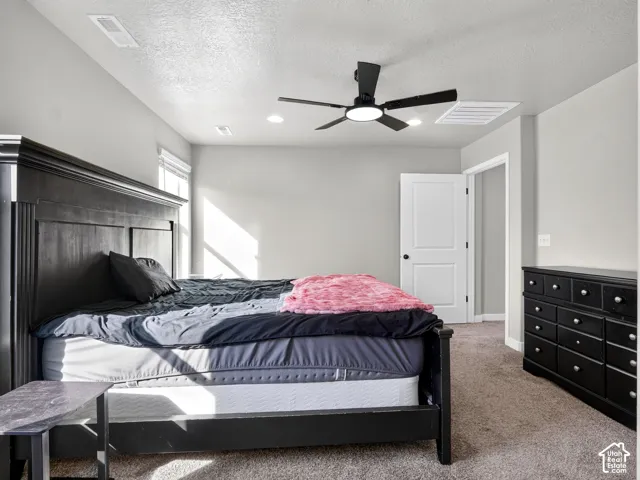 Wall-to-wall carpeting, light neutral wall tones, and a ceiling fan with integrated lighting