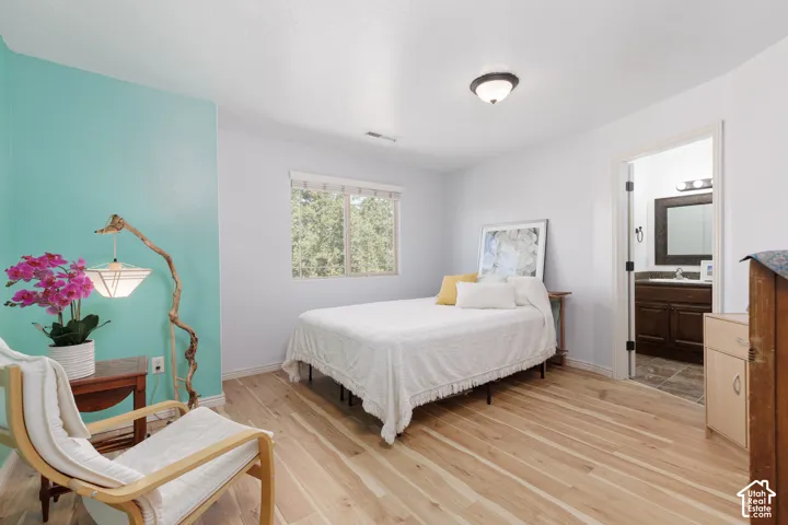 Wood-finish flooring throughout, white walls with a contrasting accent wall, and a window with blinds
