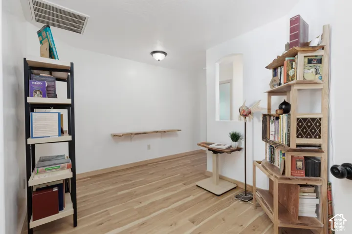 Recessed ceiling light fixture, wood-finish flooring, white walls, and a wall niche
