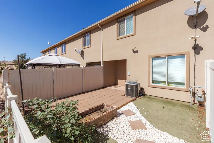 Private patio area featuring a paver surface, fenced enclosure, and artificial turf