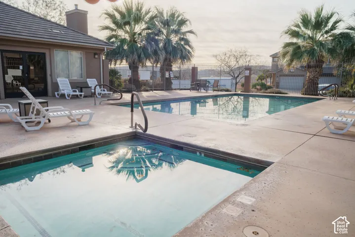 Outdoor aquatic amenity featuring two distinct pools, a surrounding concrete deck, and palm trees