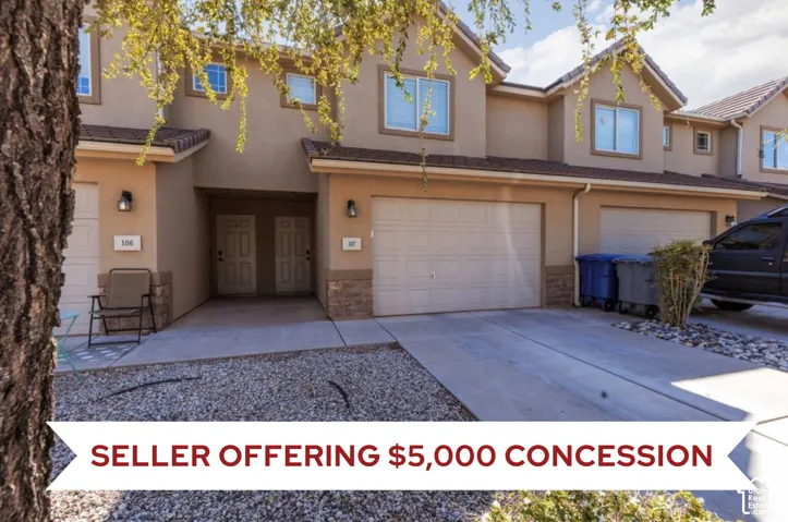 Stucco exterior with stone accents, attached garage, concrete driveway, and gravel landscaping