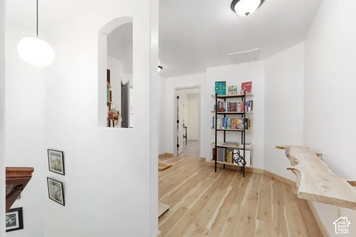 Wood-finish flooring with white walls and a rounded wall niche