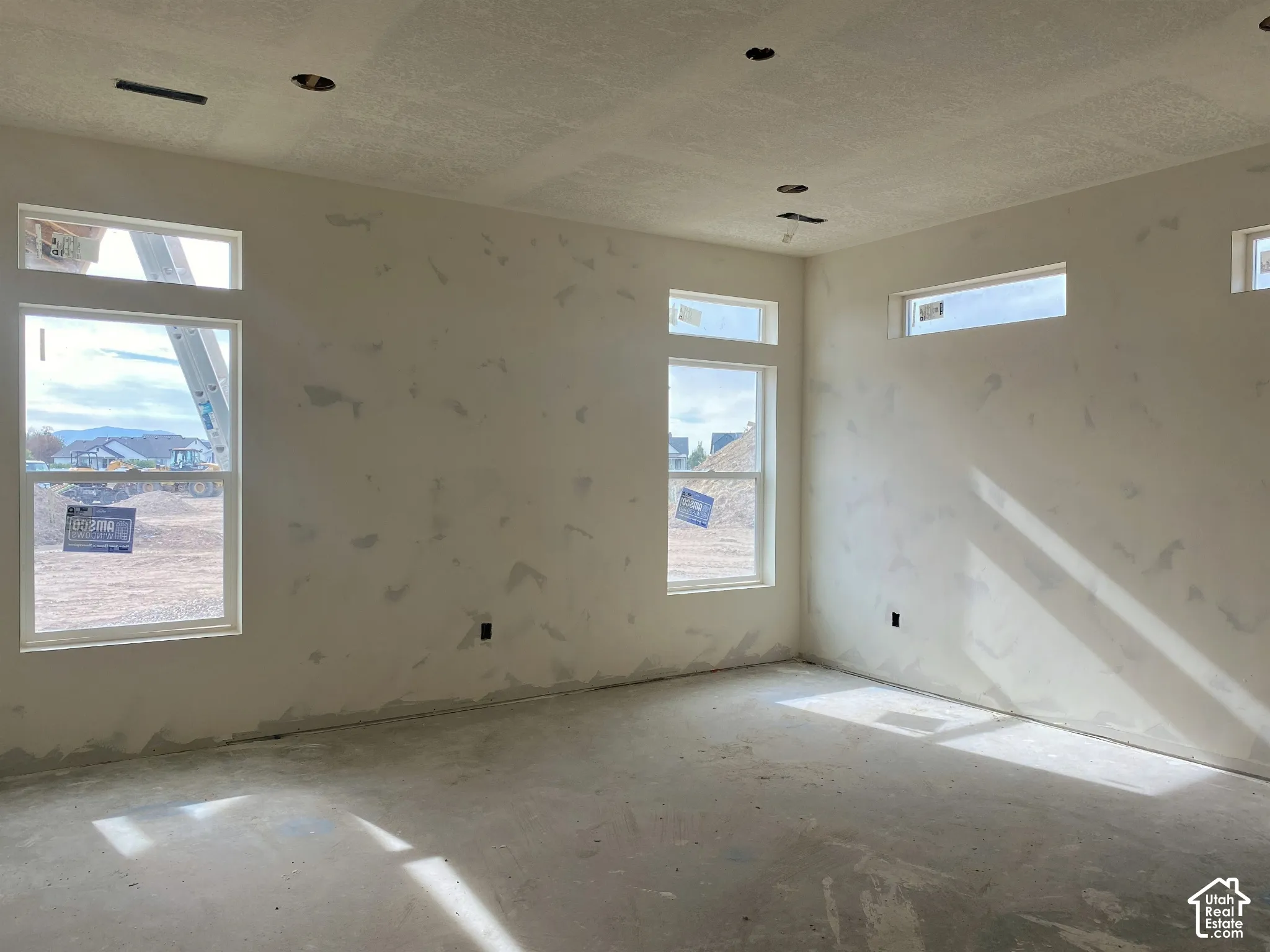Multiple windows, recessed lighting, and a neutral wall finish