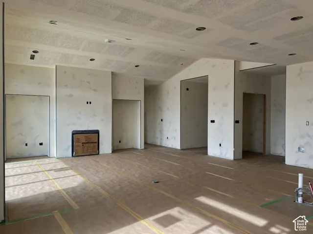 Vaulted ceiling with recessed lighting and a built-in fireplace