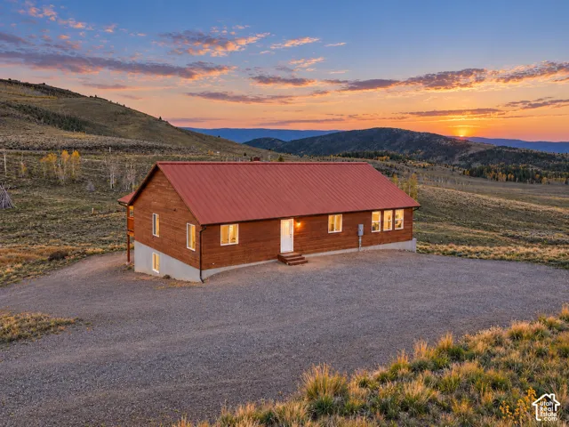 Exterior: Set into the hillside, the cabin catches the last light of the evening.