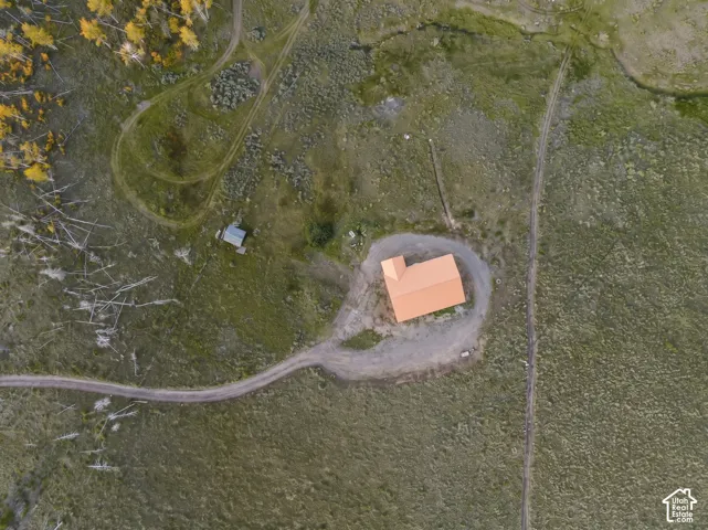 Exterior: A top-down view shows the gravel drive looping around the home and the open acreage.