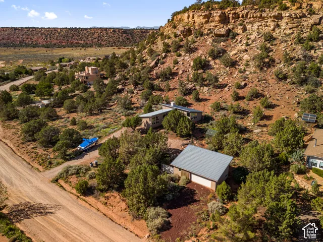 Multi-structure property featuring a modern residence, detached garage with a metal roof, and an additional dwelling