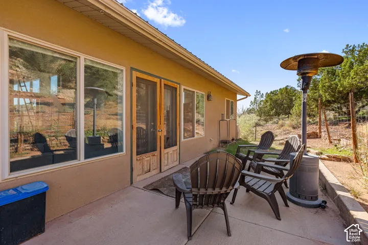 Patio with concrete surface, exterior stucco finish, and multiple windows