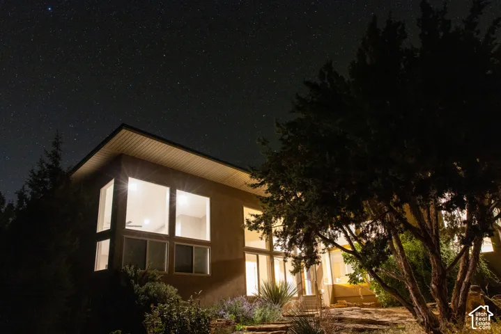 Contemporary exterior with a flat roofline, multiple large windows, and an illuminated interior
