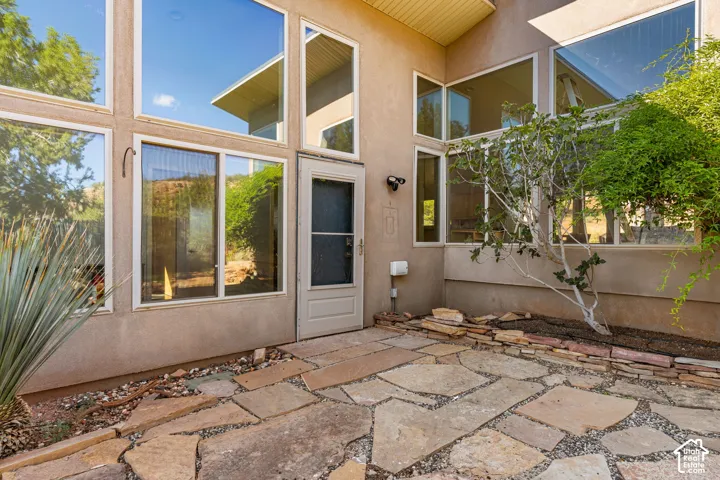 Extensive fenestration, flagstone patio, stucco exterior, and integrated exterior lighting