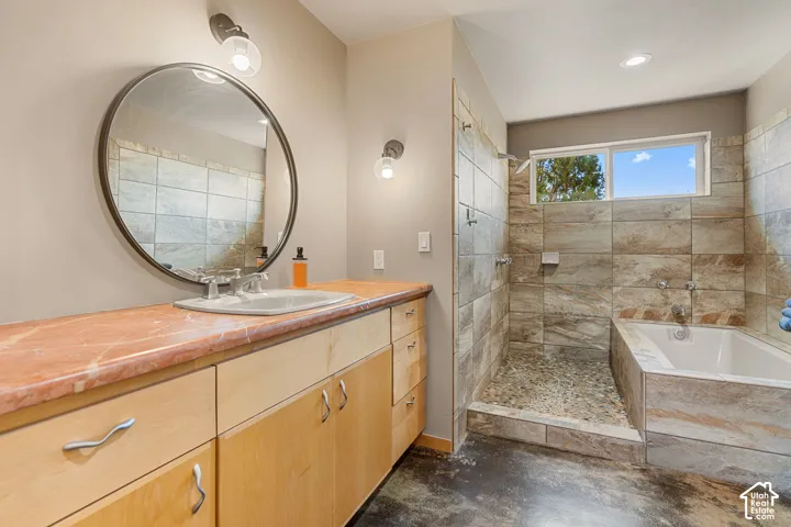 Extended vanity with a rectangular undermount sink, a large circular mirror, and two wall sconces