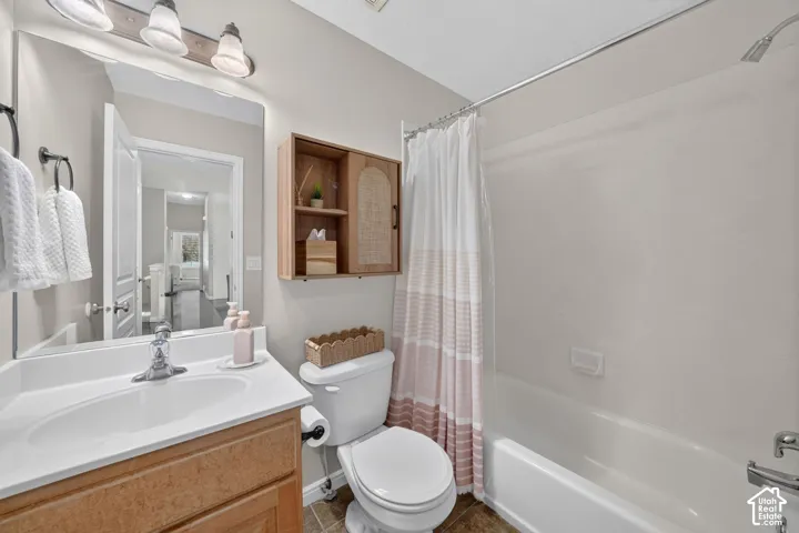 Vanity with a white countertop and integrated sink, a large wall-mounted mirror, and a three-light fixture