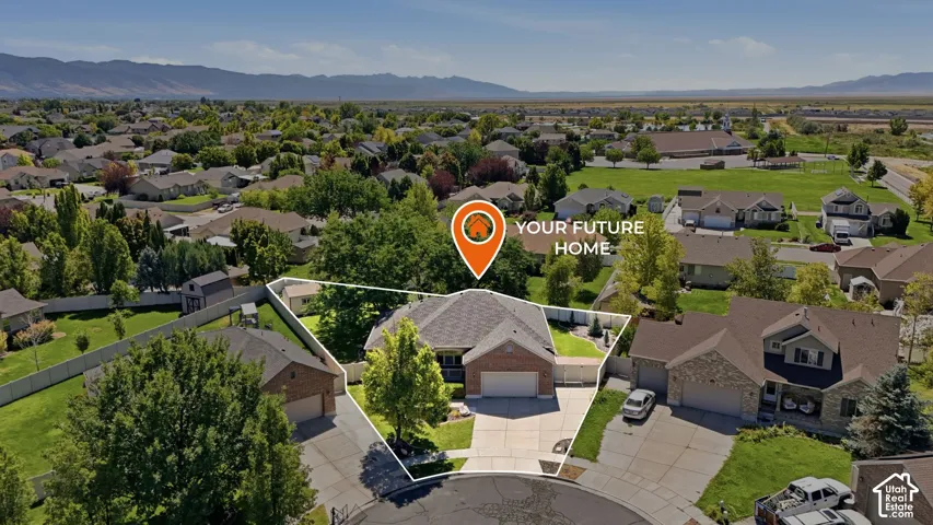 Single-story residence with an attached garage, paved driveway, and mature landscaping