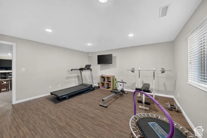 Recessed lighting illuminates the wood-finish flooring