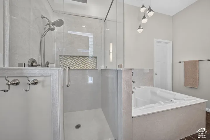Glass-enclosed shower with a handheld spray and a decorative tile niche