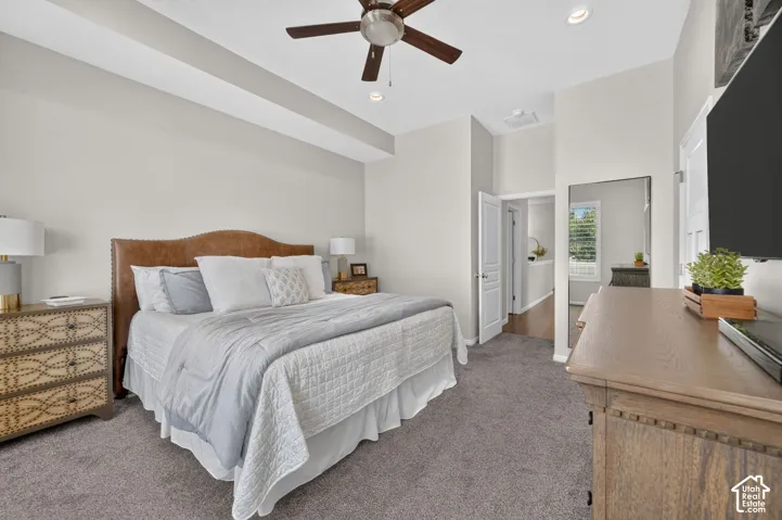 Tray ceiling with recessed lighting, ceiling fan, and carpeted flooring
