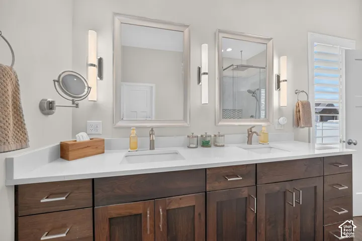 Dual vanity with white countertop, undermount sinks, and dark wood-finish cabinetry