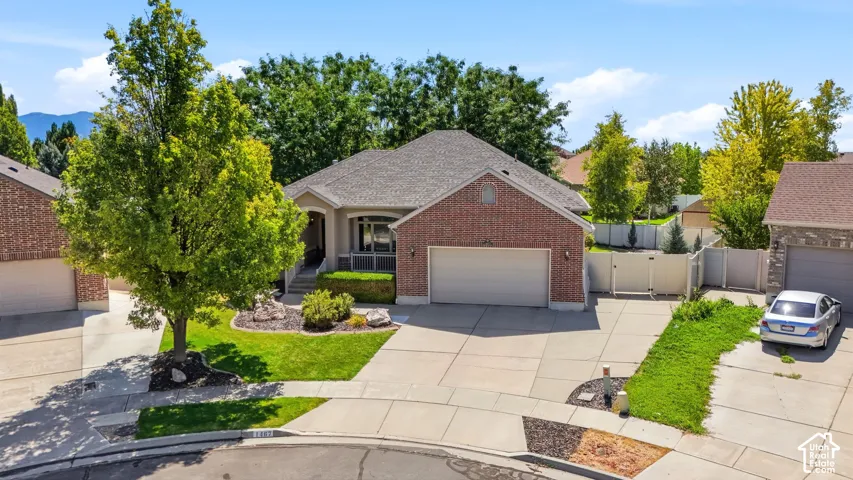 Brick exterior with a covered porch entry, an attached two-car garage, and a concrete driveway