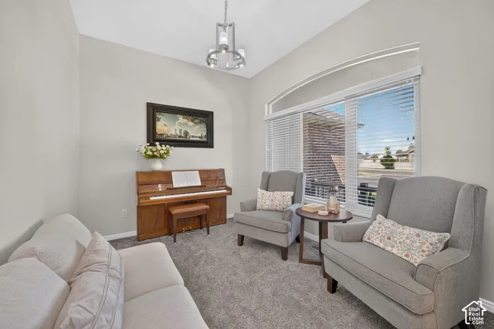 Arched window with blinds, vaulted ceiling, recessed lighting, and grey carpet flooring