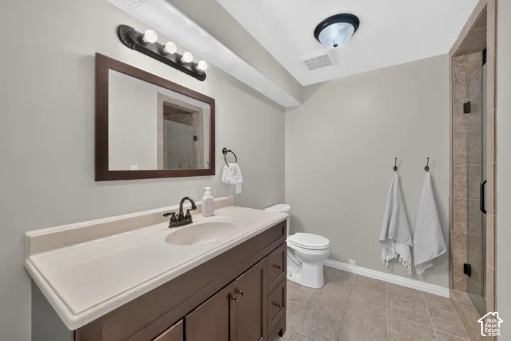 Vanity with integrated sink, dark wood-finish cabinetry, and framed mirror