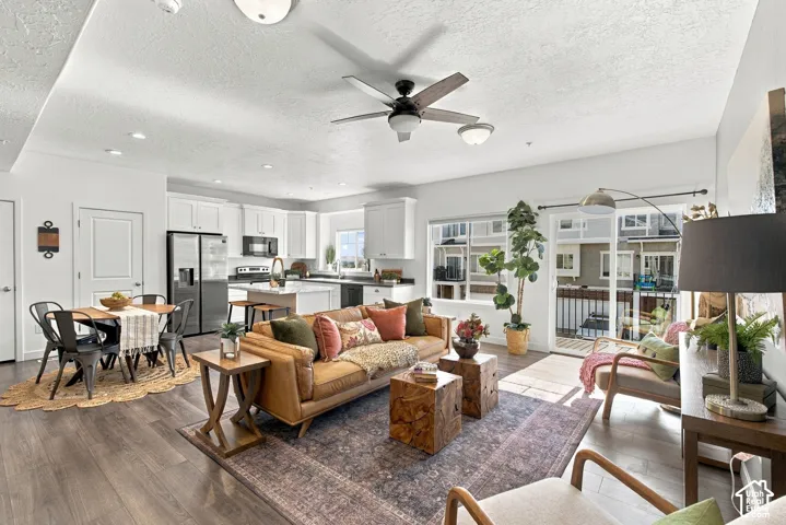Open-concept living space with wood-finish flooring, a contemporary ceiling fan, and recessed lighting