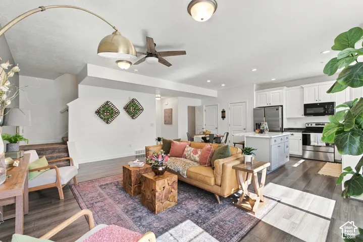 Open-concept living space with wood-finish flooring, recessed lighting, and a ceiling fan