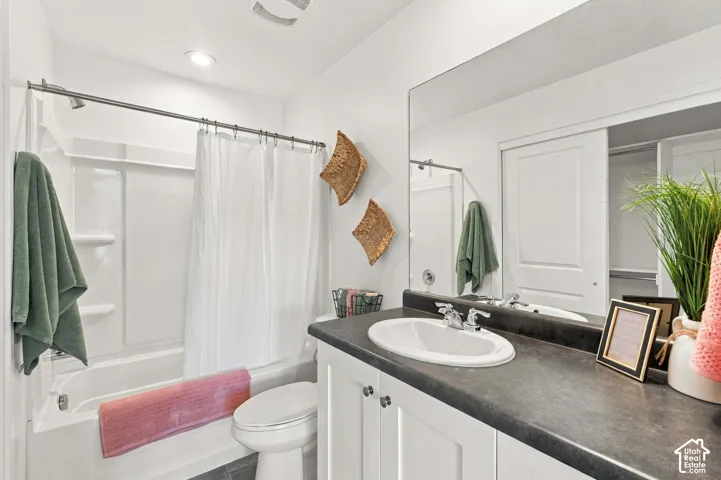 White vanity with a dark countertop and integrated sink