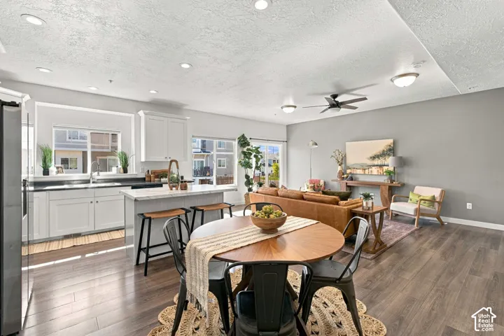Open-concept living space with wood-finish flooring, recessed lighting, and a ceiling fan