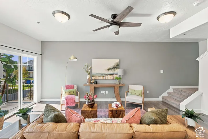 Spacious living area featuring wood-finish flooring, a ceiling fan, recessed lighting, and sliding glass doors