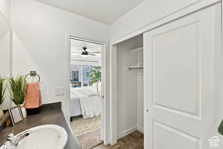 Bathroom vanity with a round basin sink and dark countertop