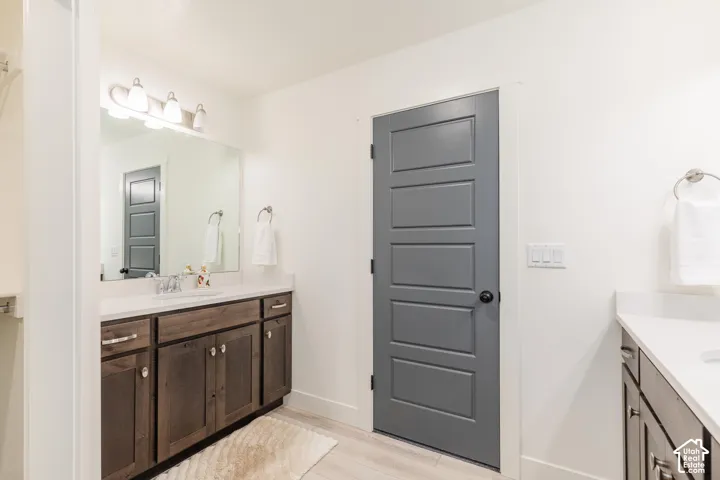 Double vanity with white countertops, dark wood cabinetry, and chrome hardware
