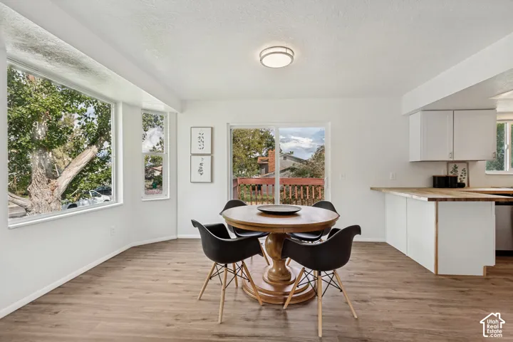 Wood-finish flooring, white walls, and a large bay window