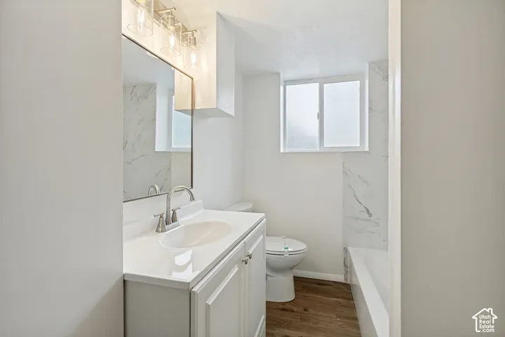 White vanity with brushed nickel fixtures, integral sink, and a large mirror