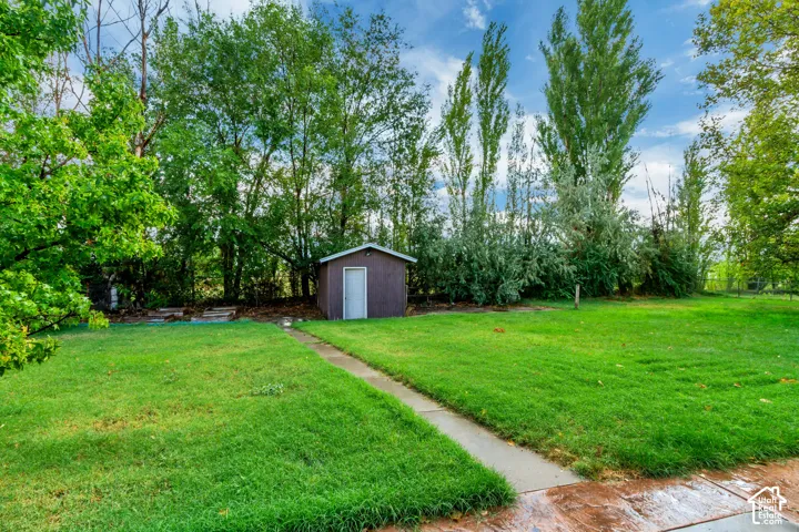 Expansive green lawn with a concrete pathway and mature trees