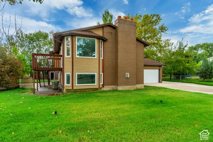 Two-story exterior with a deck, ground-level patio, and an attached garage