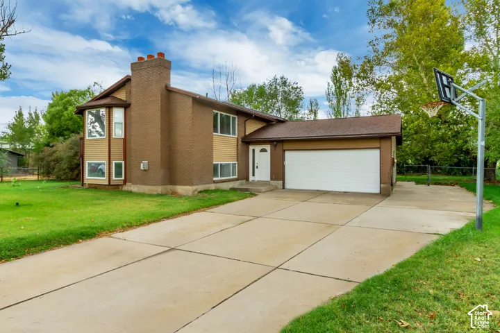 Two-story residence with a brick chimney, bay window, and attached garage