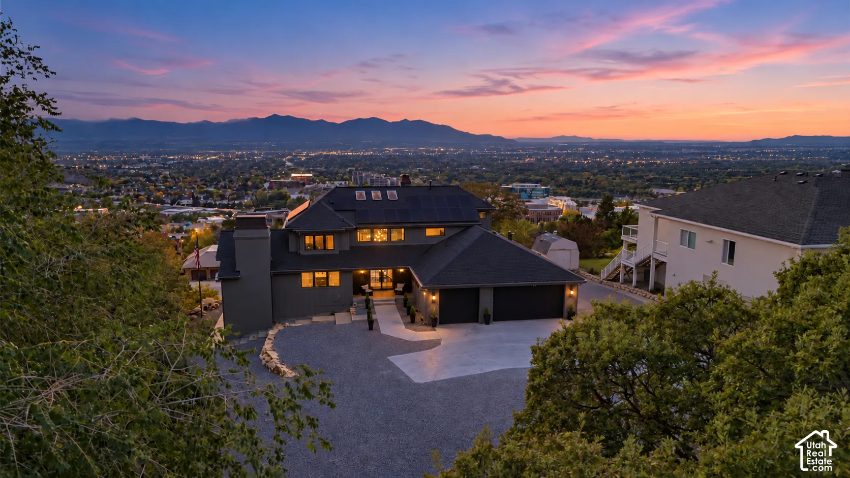 Expansive multi-level residence featuring a gray exterior and a multi-car garage