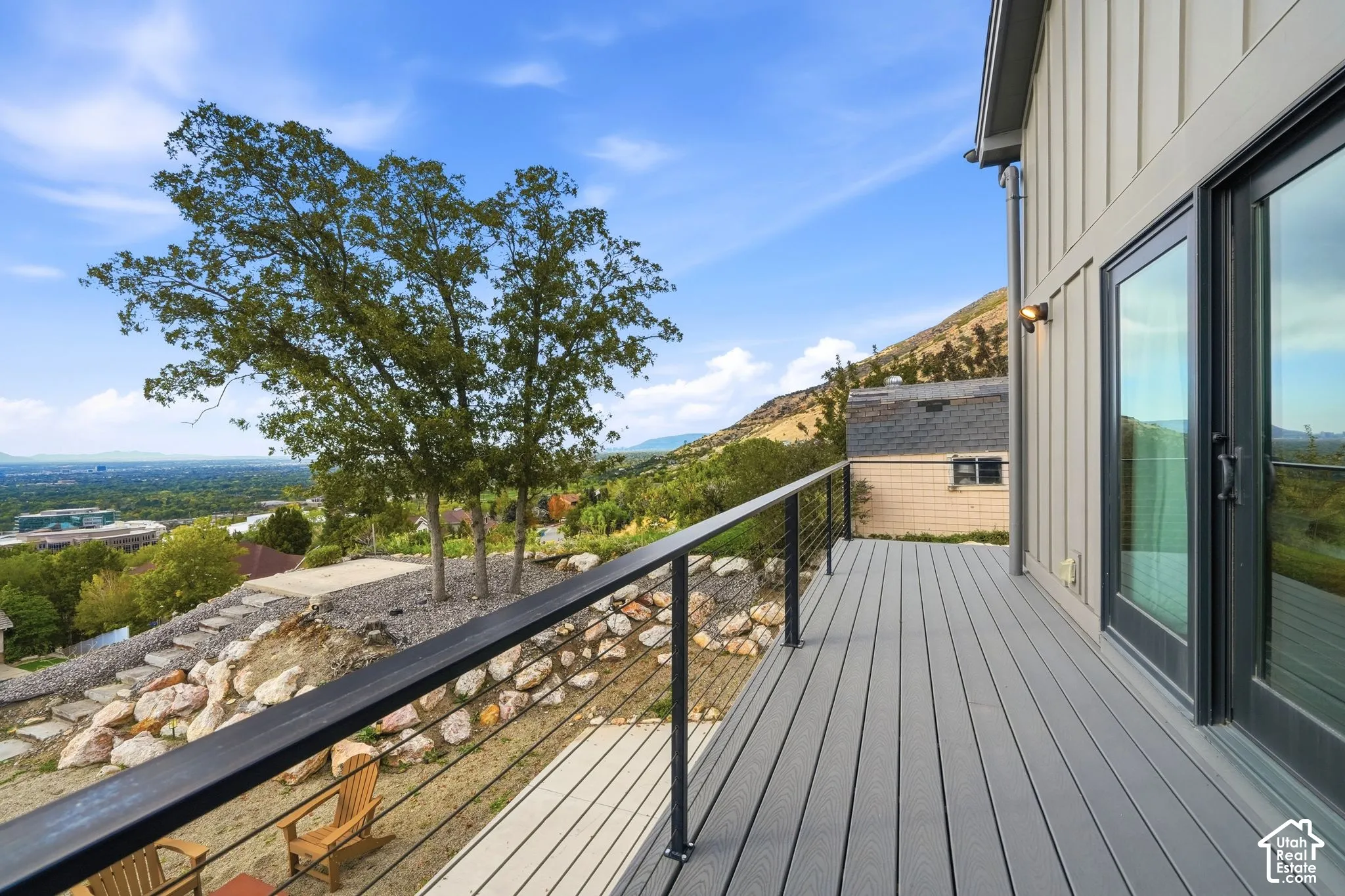 Expansive deck featuring composite decking, cable railing, and sliding glass doors