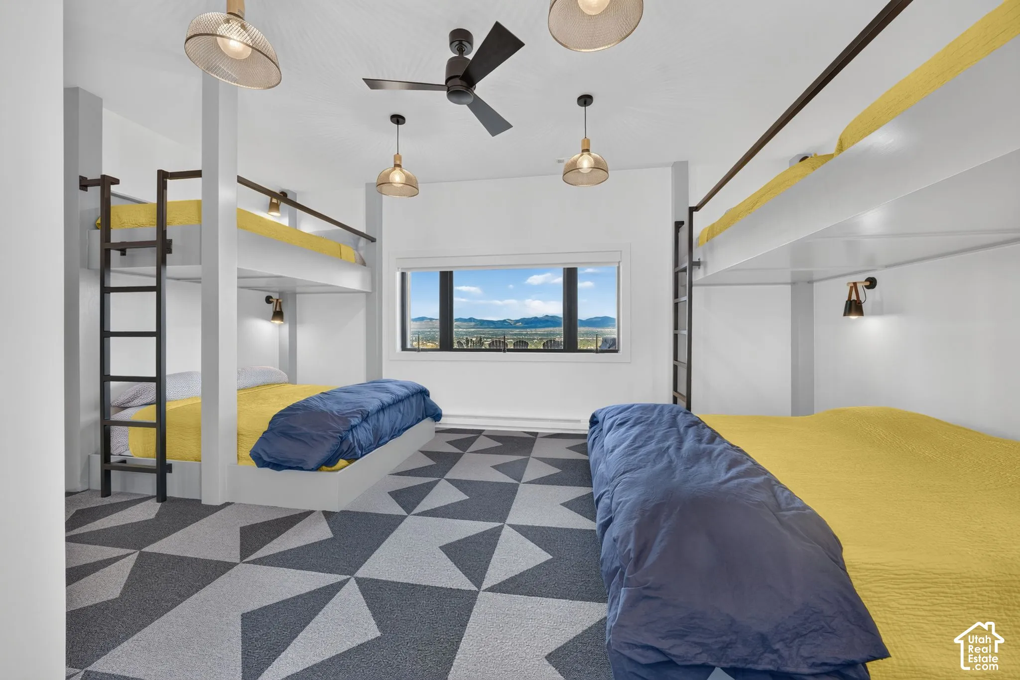 Built-in bunk beds with integrated ladders, geometric patterned carpet, and a large picture window with distant mountain scenery