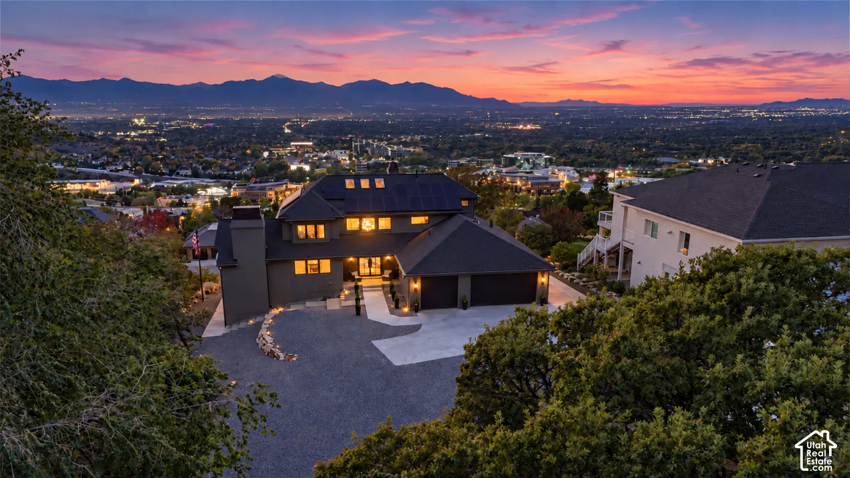 Contemporary home with a two-car garage, solar panels, and a paved driveway