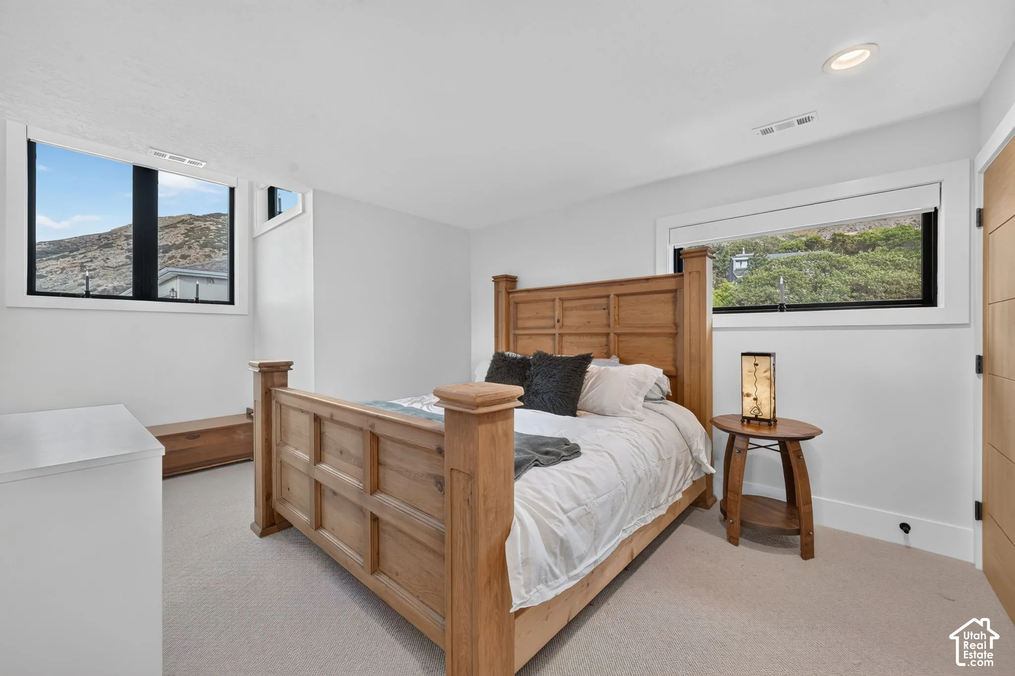 White walls, light-toned carpeting, recessed ceiling lighting, and horizontal windows