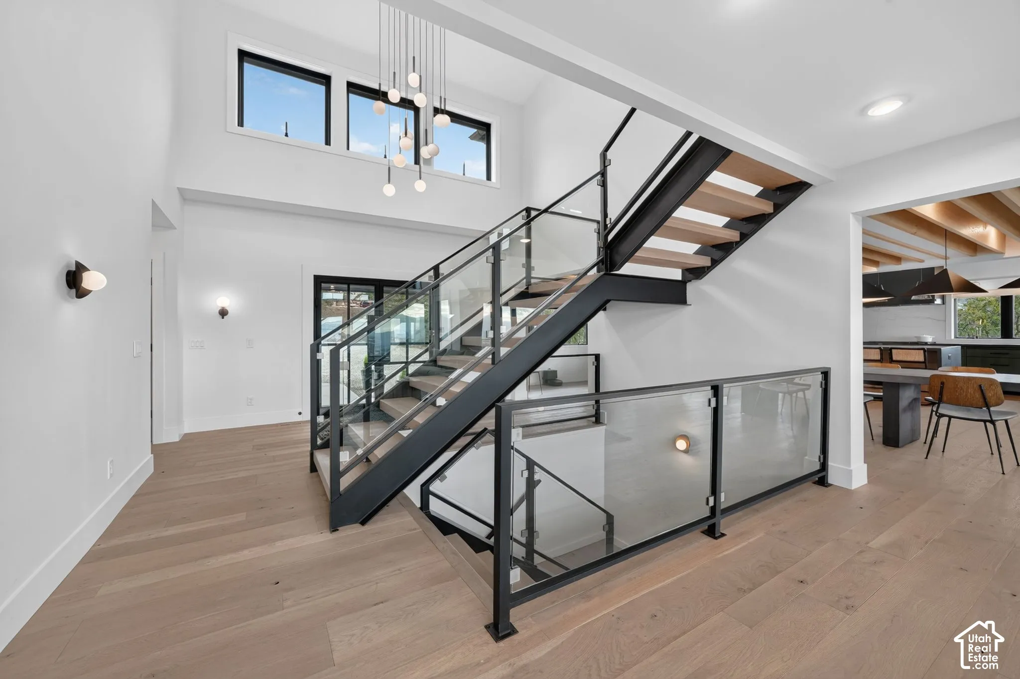 Two-story entryway featuring wood-finish flooring and a contemporary chandelier