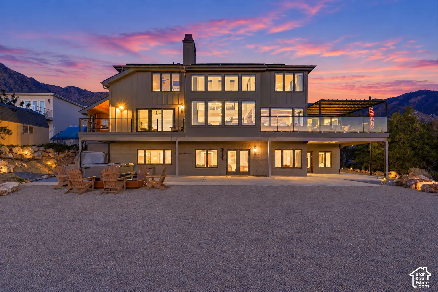 Multi-level residence featuring extensive window placements and a large elevated deck with glass railing