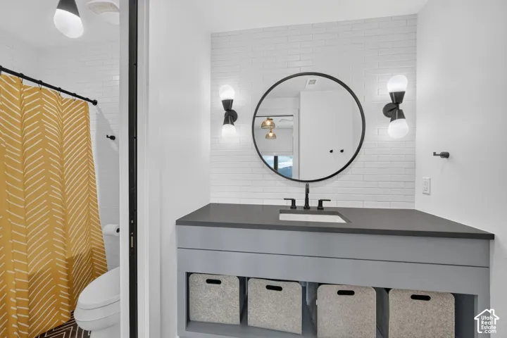 Vanity with a rectangular undermount sink, dark countertop, and matte black faucet